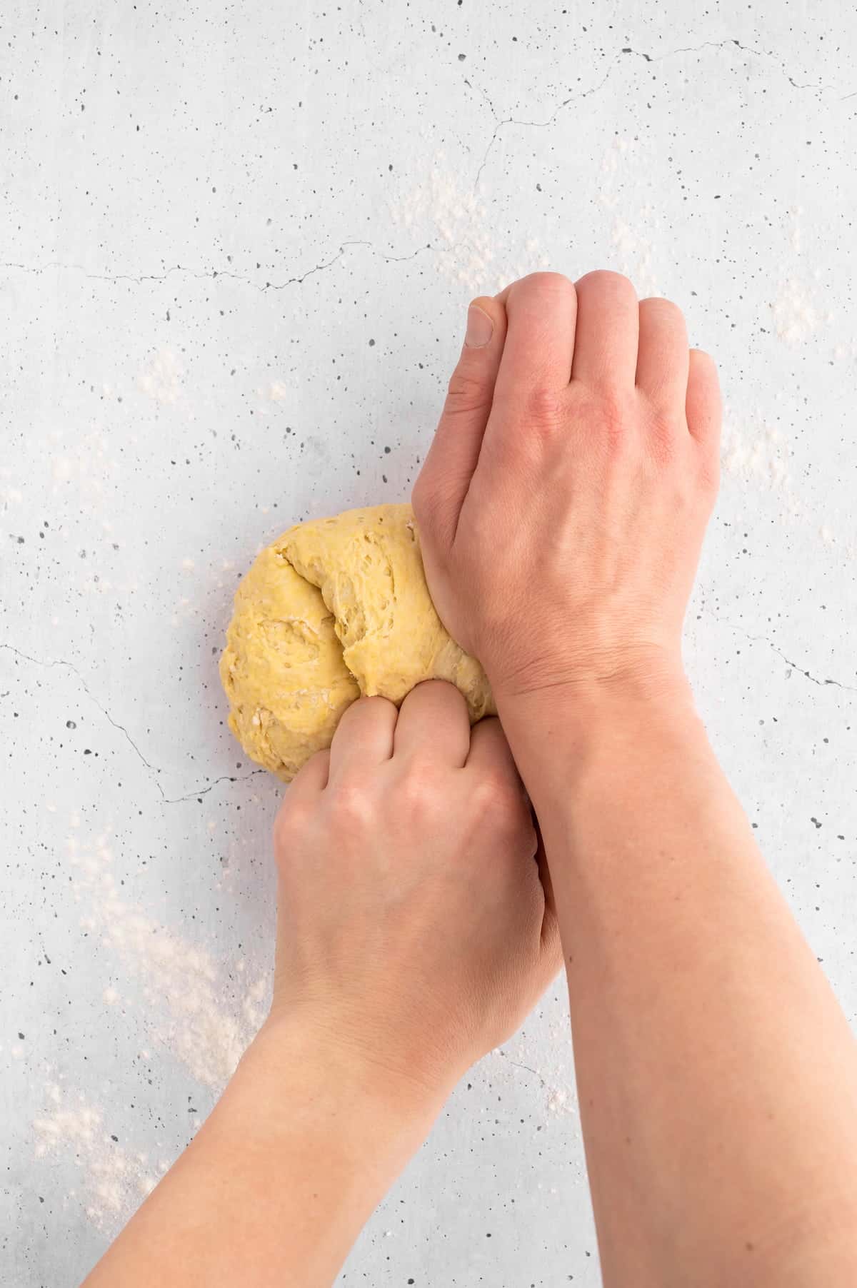 Hands kneading ravioli dough.