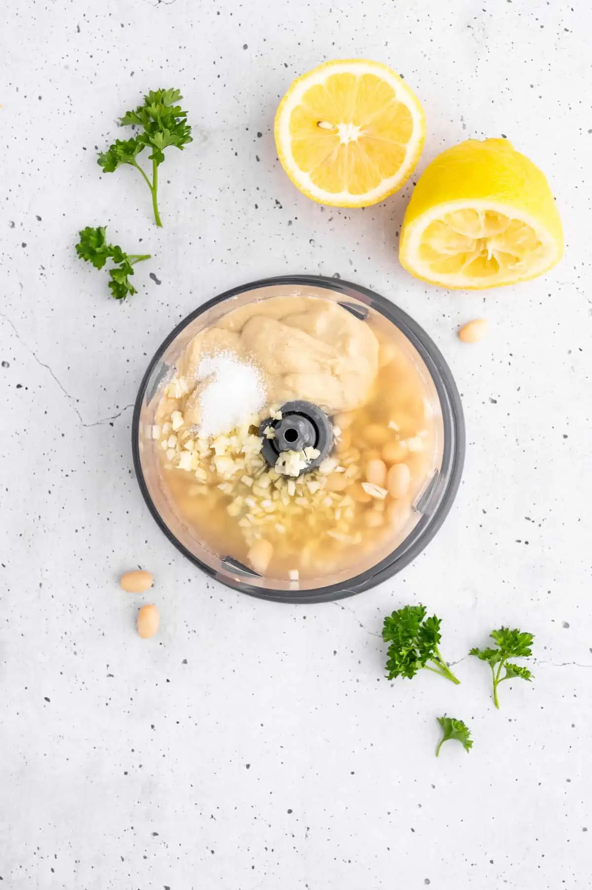 Ingredients for white bean hummus in a food processor.