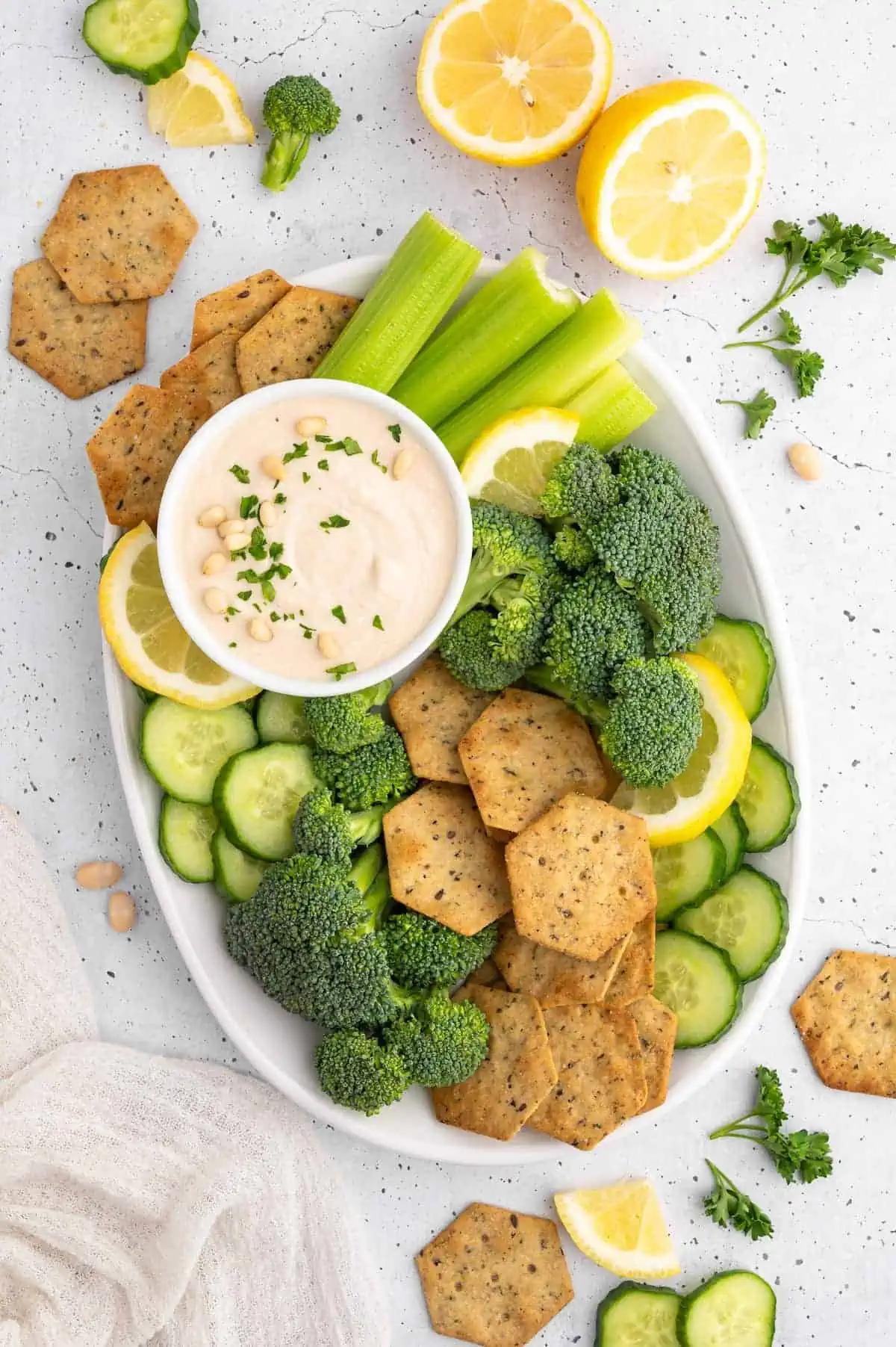 A plate of vegetables and crackers with white bean hummus.