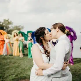 Lizzy and Tiffany's wedding photography in Cleveland with a colorful rainbow wedding party behind them.