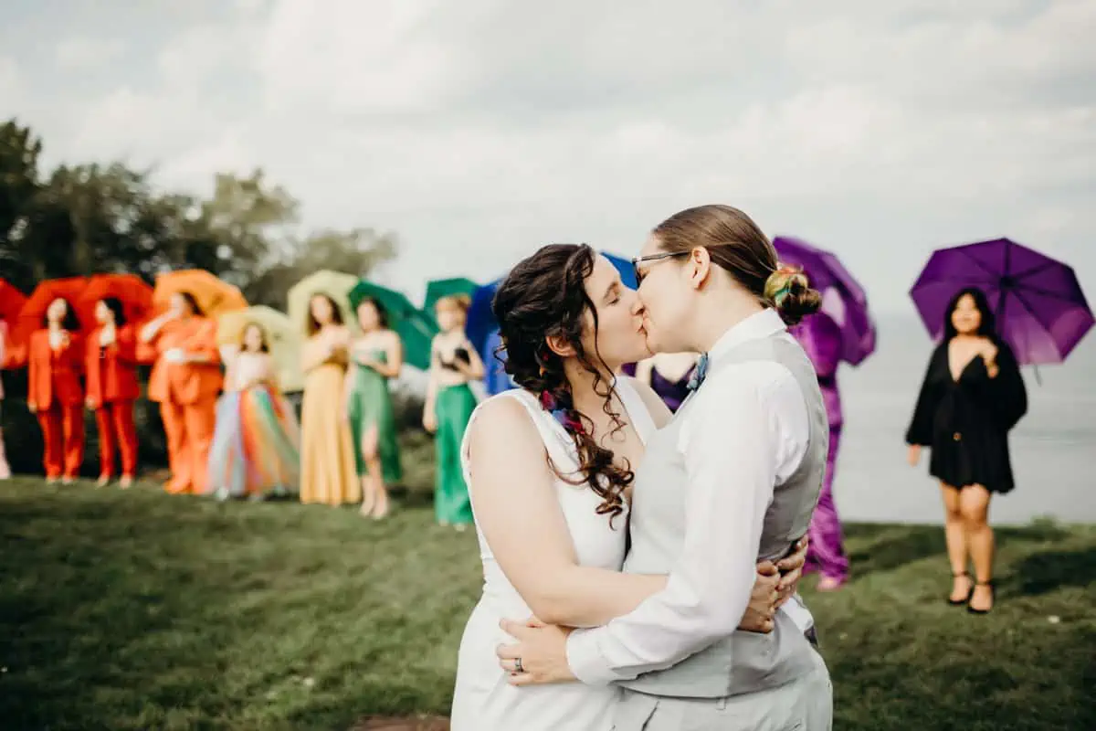 Lizzy and Tiffany's wedding photography in Cleveland with a colorful rainbow wedding party behind them.