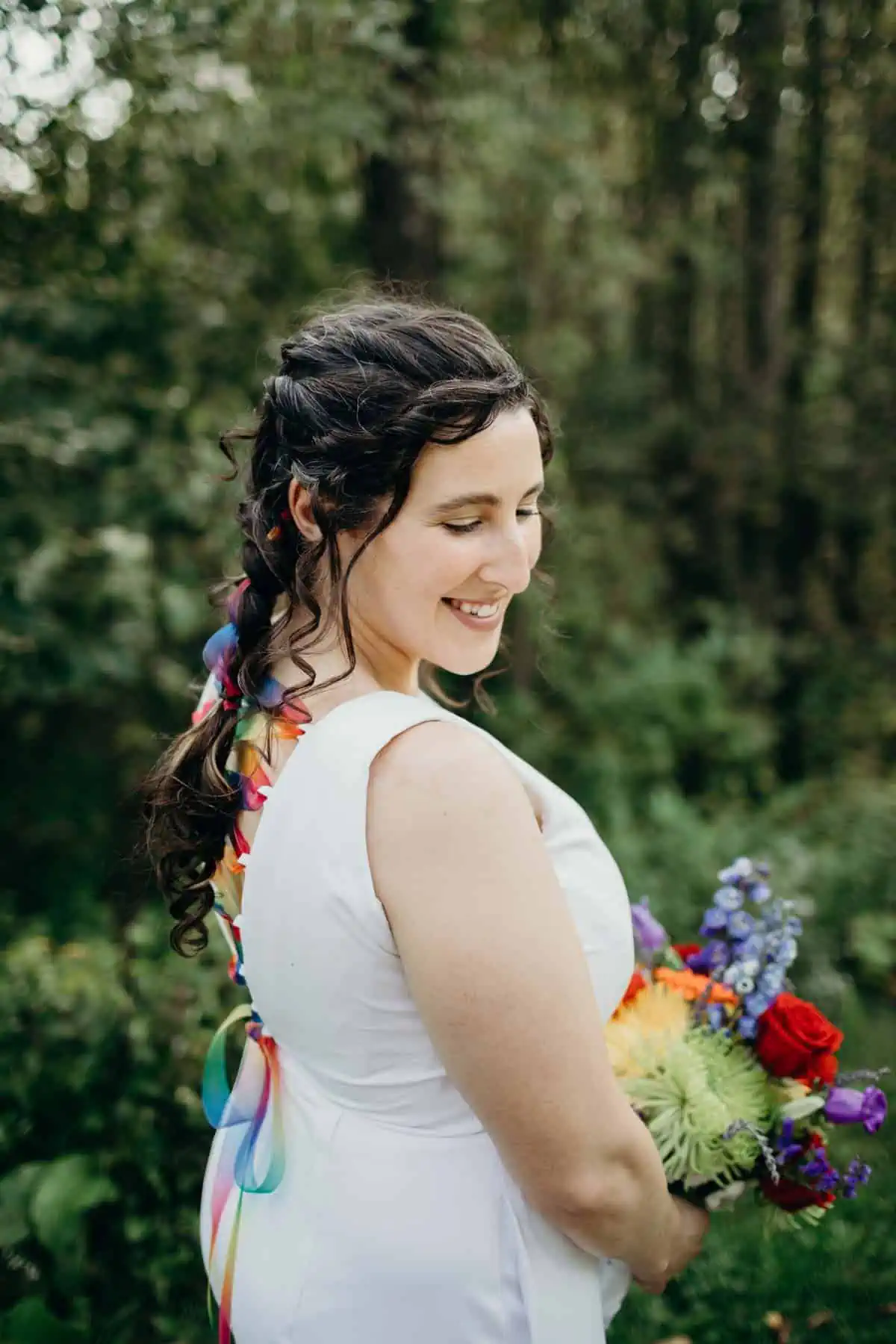 Alternative wedding dress rainbow accents with colorful ribbon woven through a white jumpsuit.