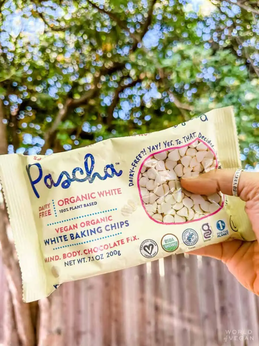 Hand holding a bag of Pascha vegan white chocolate chips.
