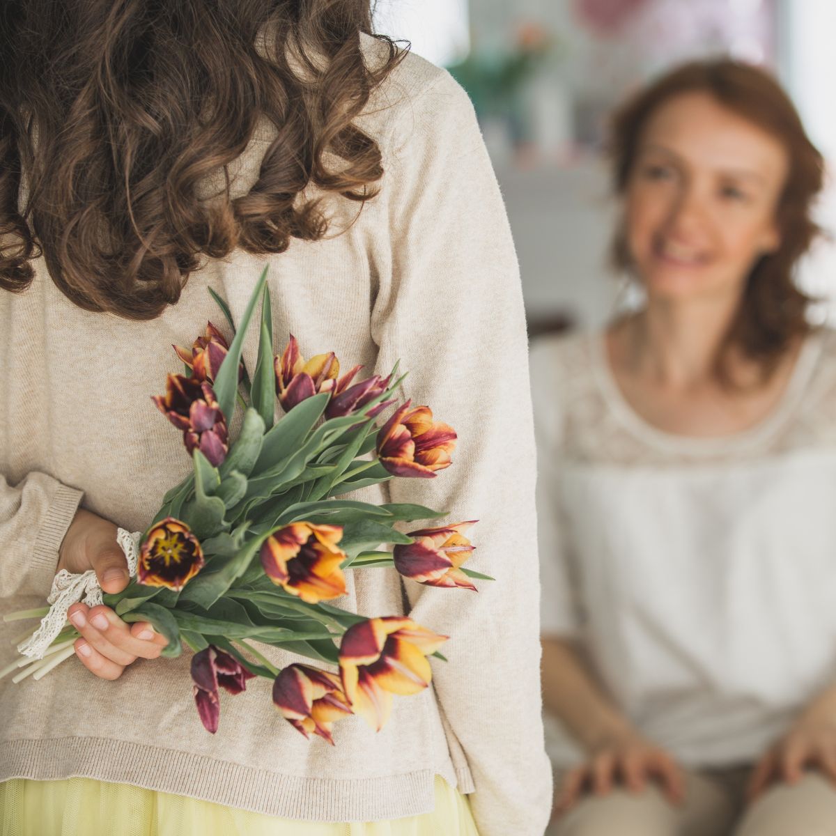 A daughter bringing her mother a gift of flowers.