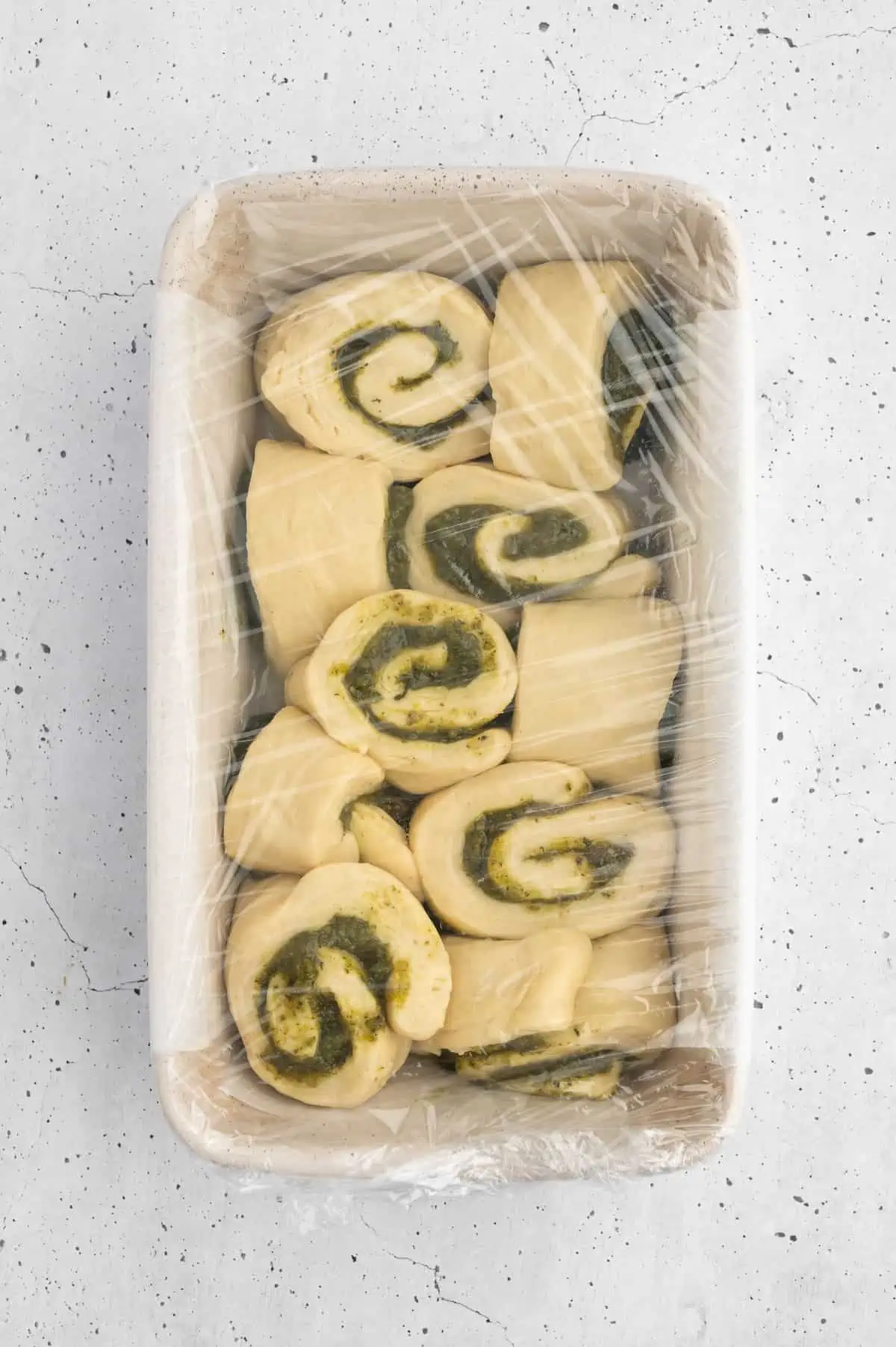 Pesto bread pieces assembled in a baking sheet to rise.