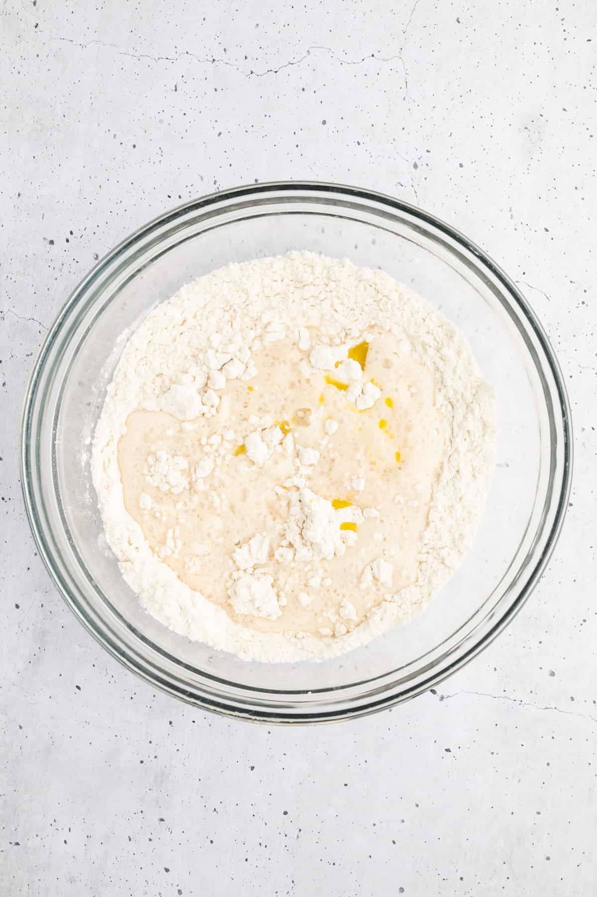 A proofed yeast mixture and flour combined in a bowl.