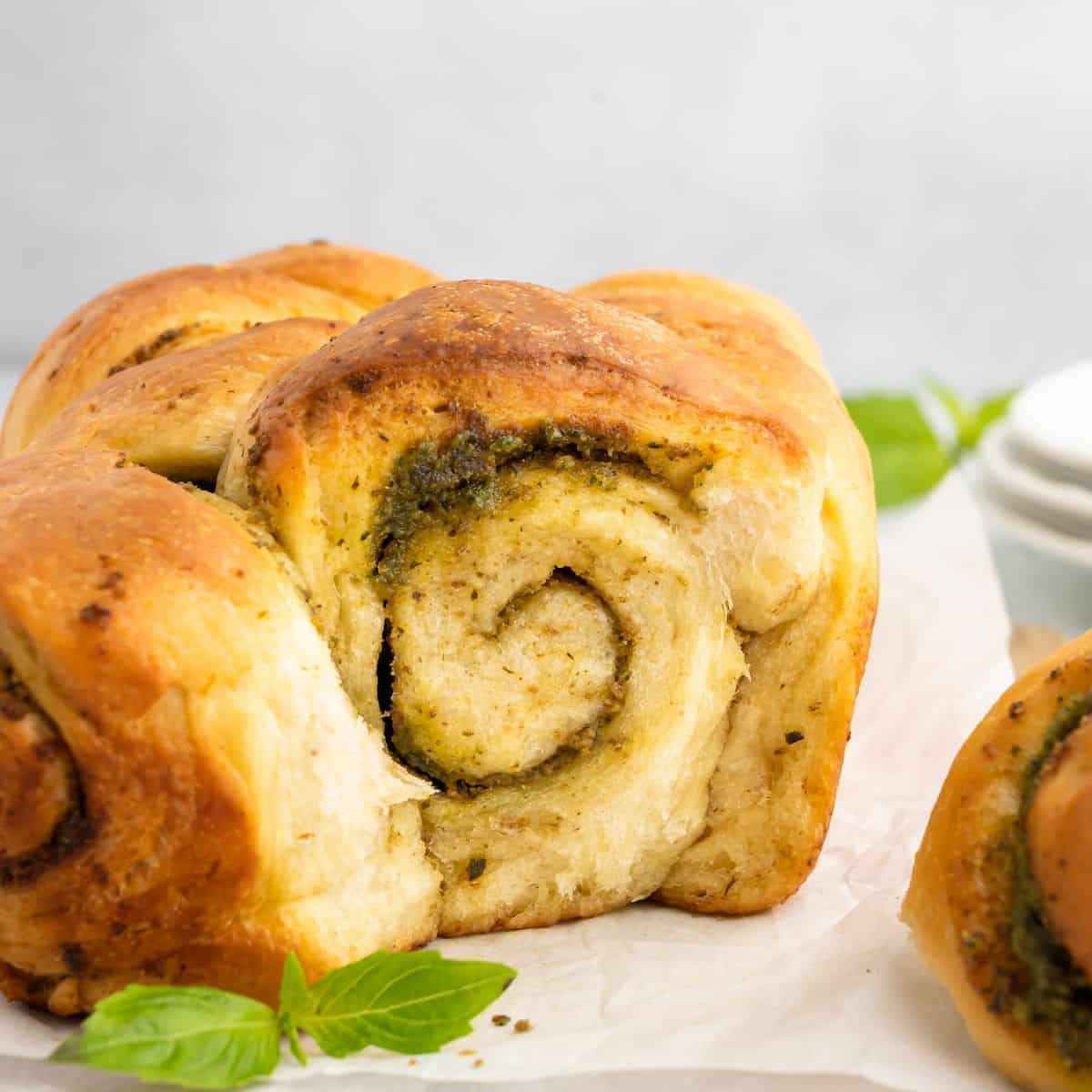 A piece of pesto bread showing an interior swirl pattern.