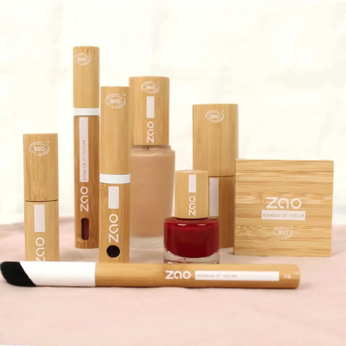 A collection of eight vegan and cruelty-free Zao Makeup products in bamboo wood containers in various sizes and shapes on a surface against white background.