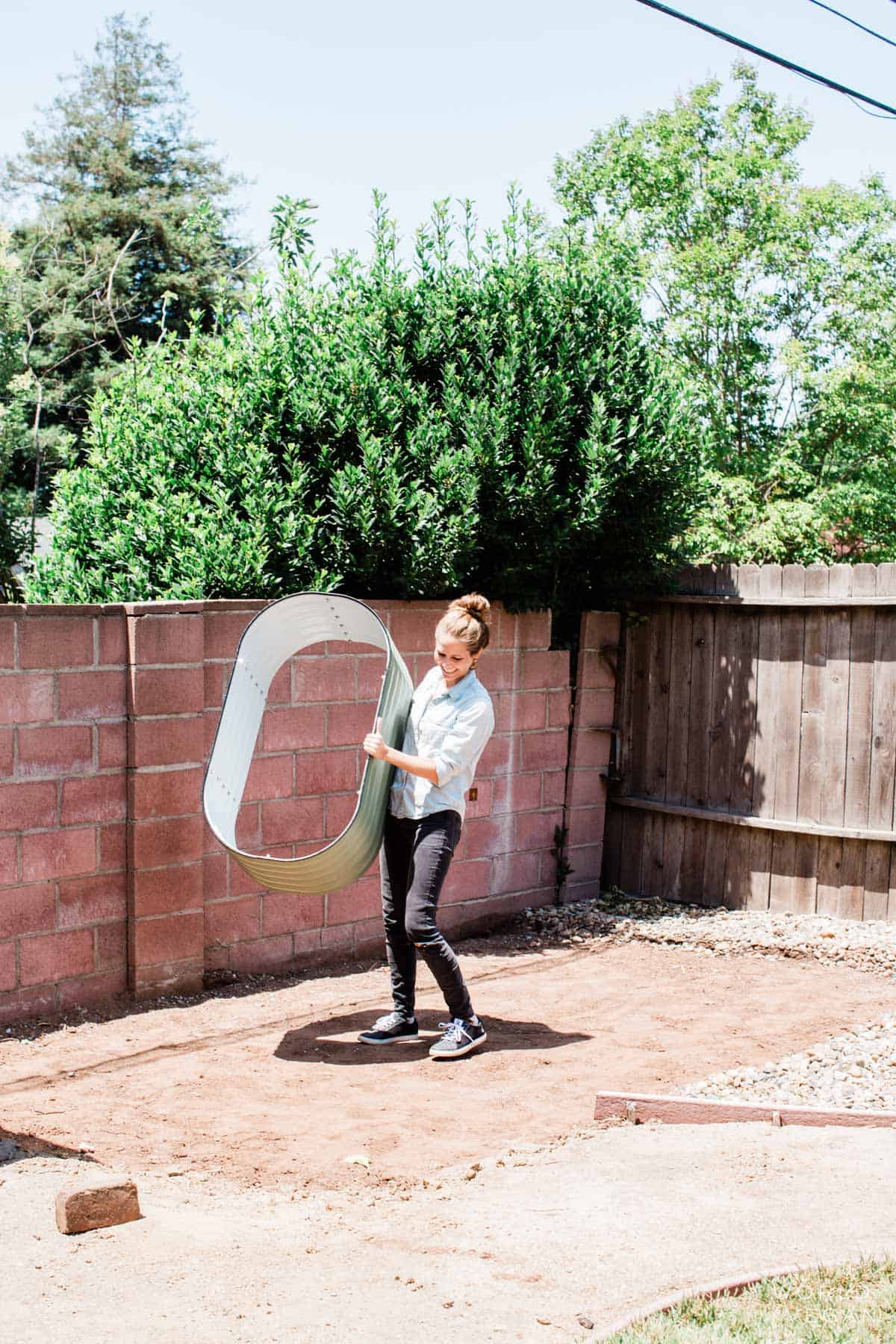 Michelle Cehn laying the new metal Vego garden beds in the yard garden area. 