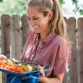 Vegan woman holding tray of tofu kebabs ready for the grill.