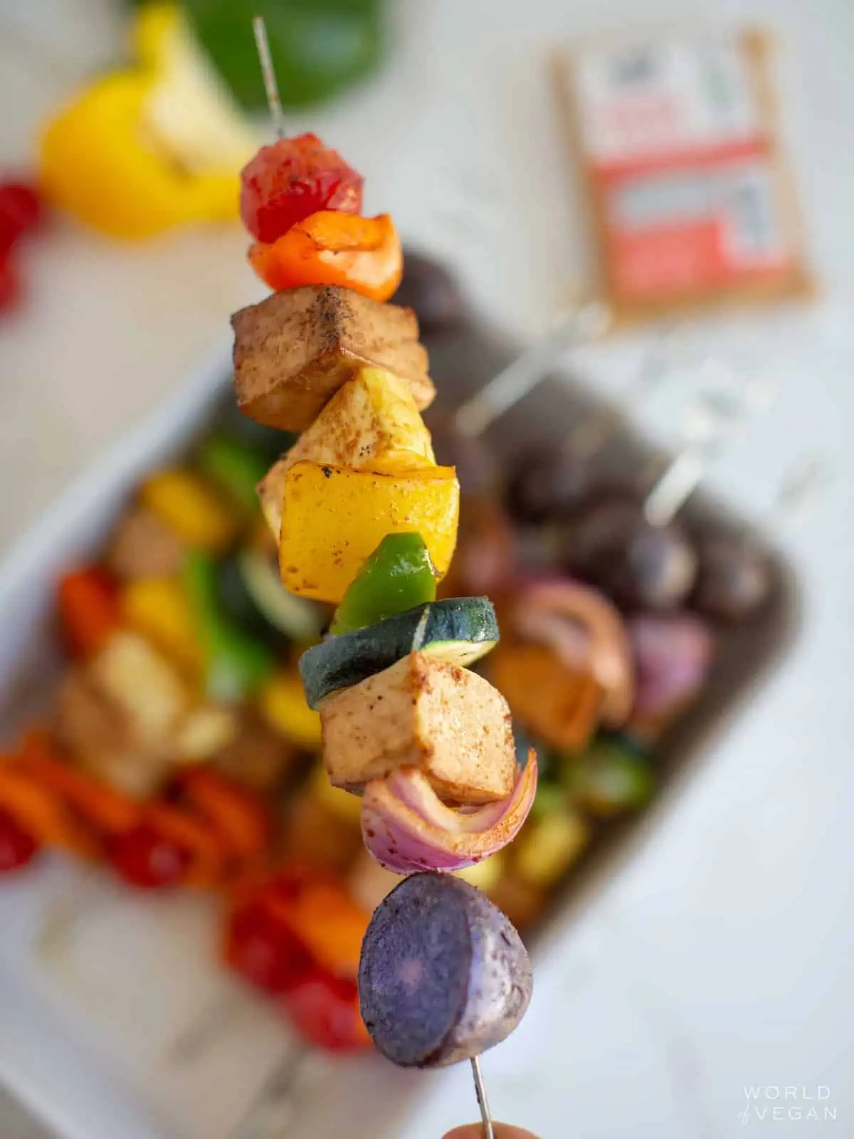 Up close of one tofu kebab with the rest blurred in the background behind it.