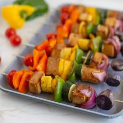 Rainbow veggie tofu kebabs on a tray.