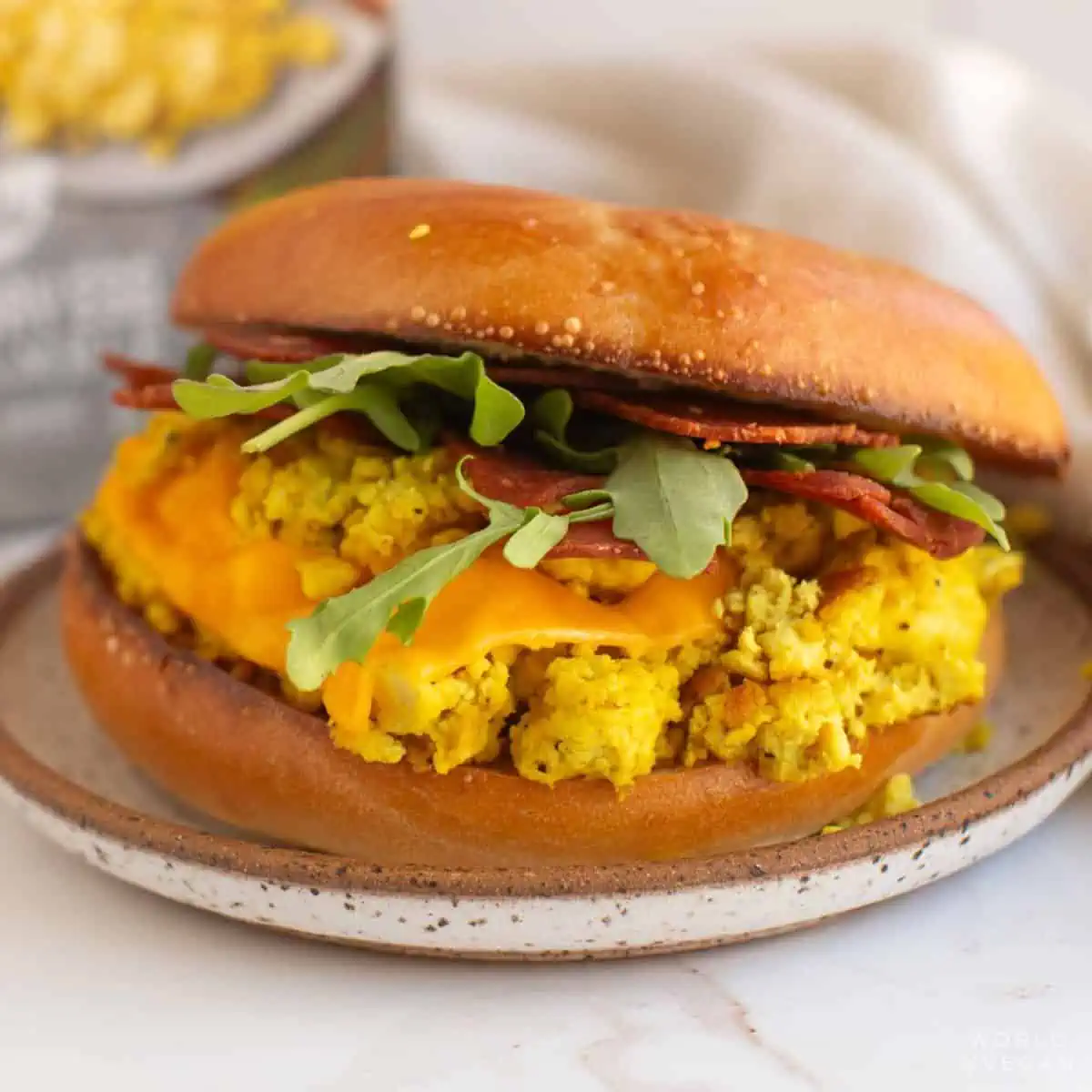 A vegan breakfast sandwich on a plate.