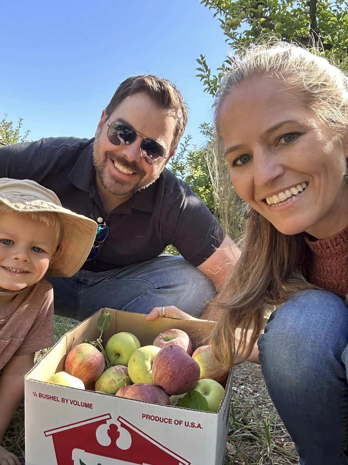 Michelle Cehn, Dan Miller, and Graham Miller picking apples at a farm in Apple Hill near Sacramento, California. 