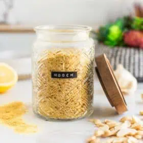 A jar labeled "nooch" and filled with nutritional yeast.