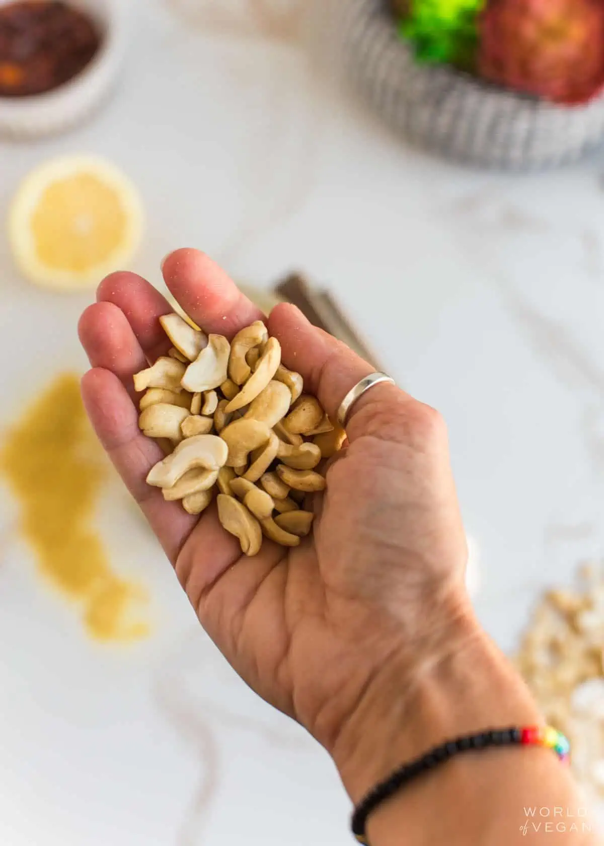 Raw cashews in the palm of a hand.