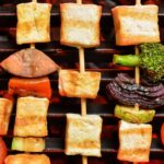 Grilled tofu and veggies on wooden skewers.
