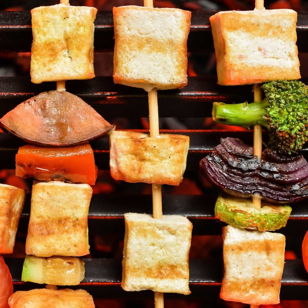 Grilled tofu and veggies on wooden skewers.
