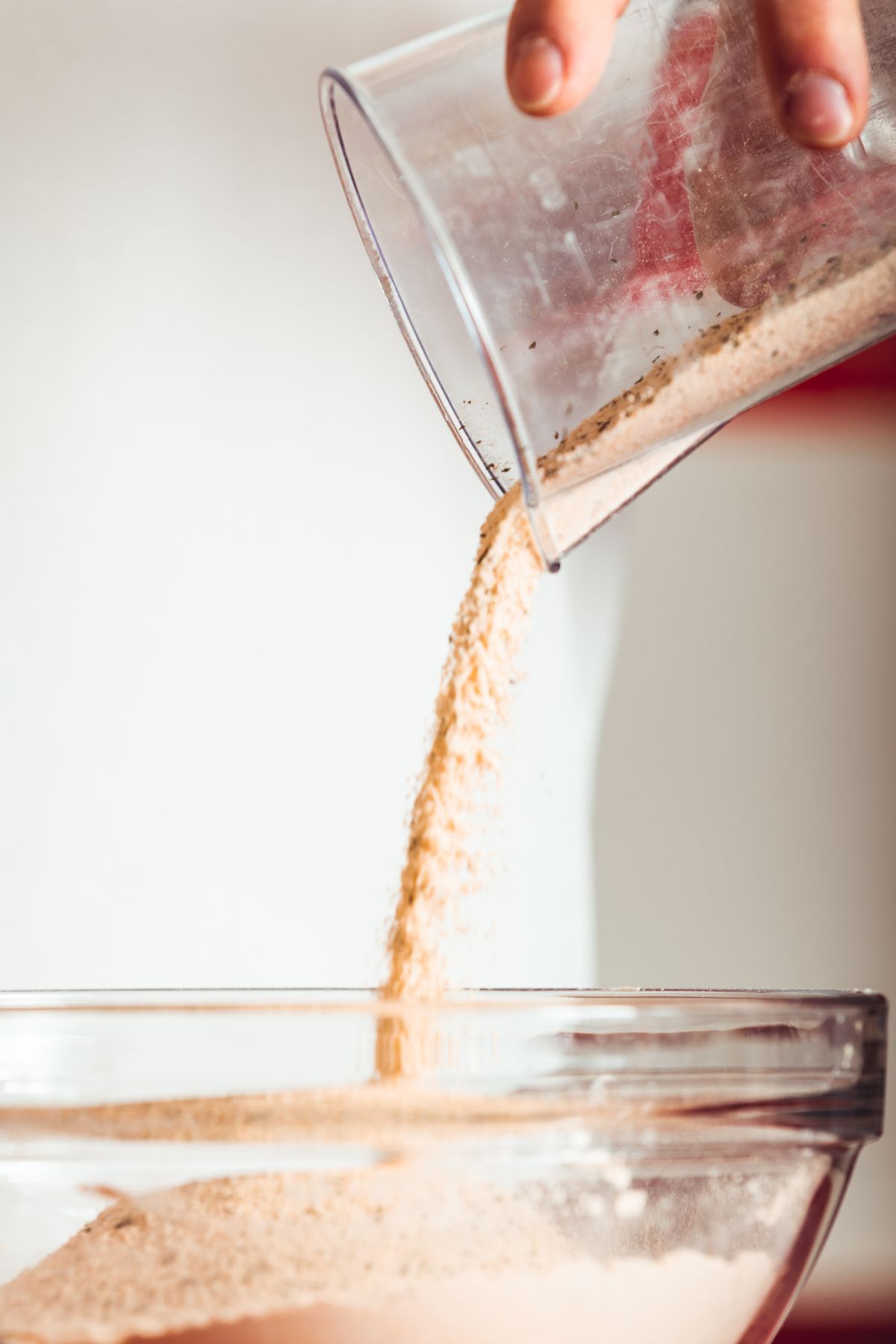 Vital wheat gluten being poured into a bowl.