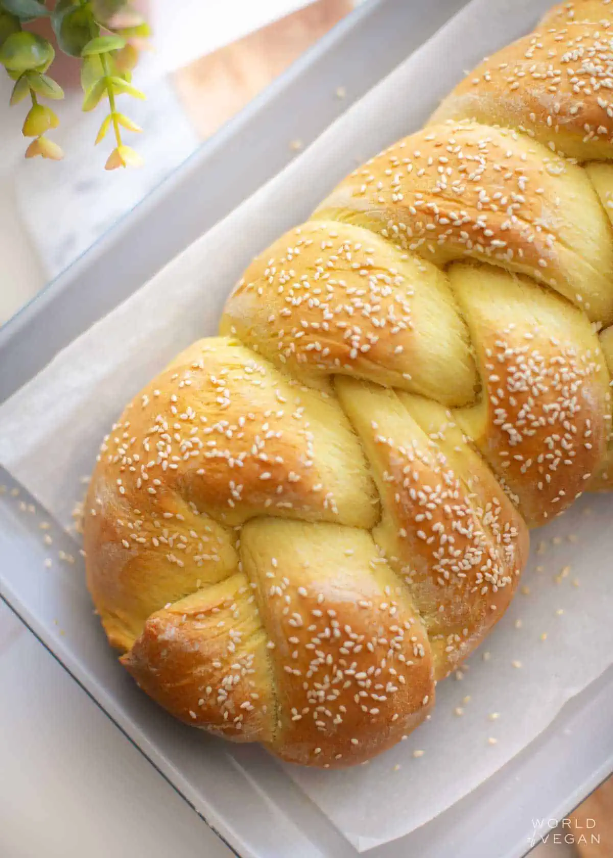 Baked vegan challah loaf on a baking sheet.