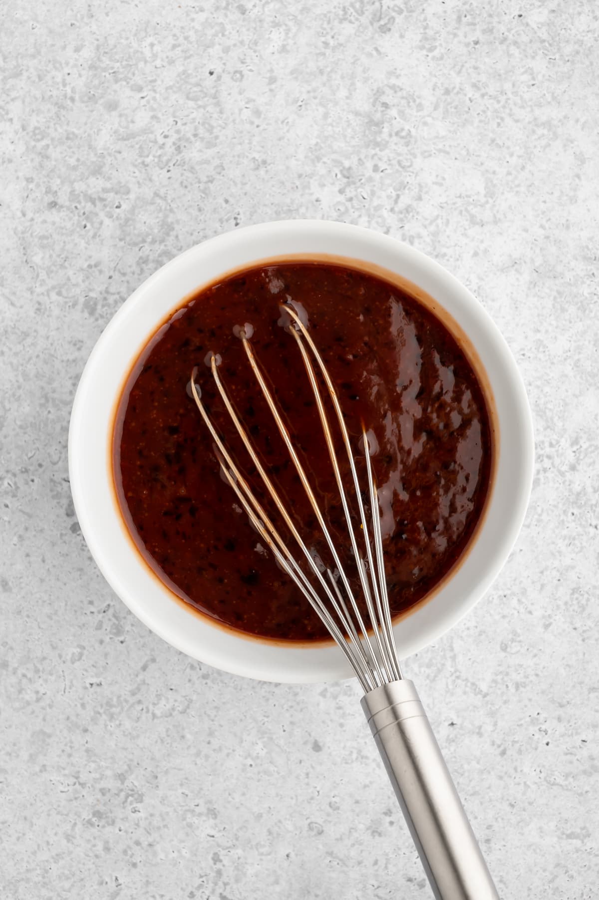 Grape jelly and bbq sauce mixed together in a bowl.