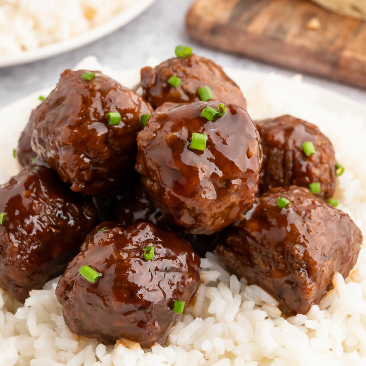 A pile of vegan bbq meatballs on a plate served with rice.
