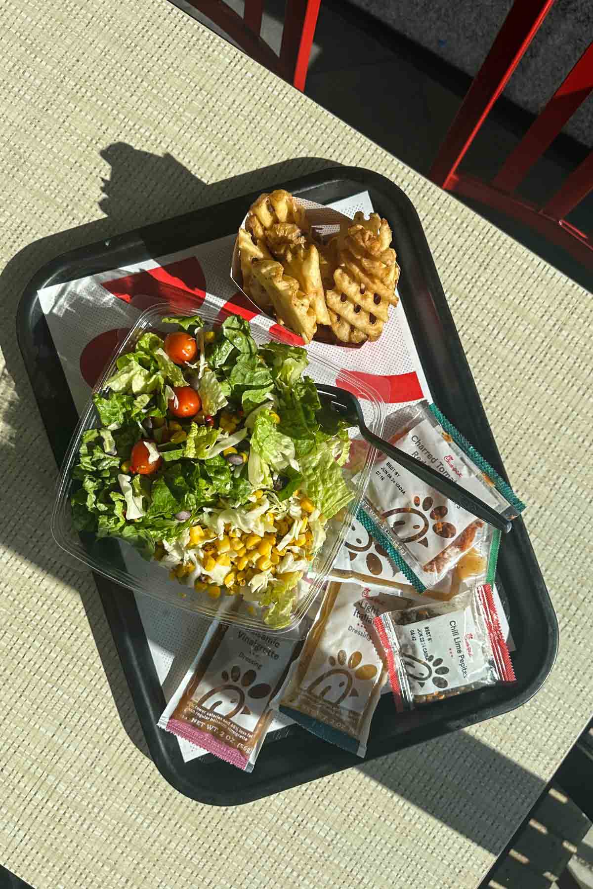 A vegan salad and waffle fries at Chick-fil-A.