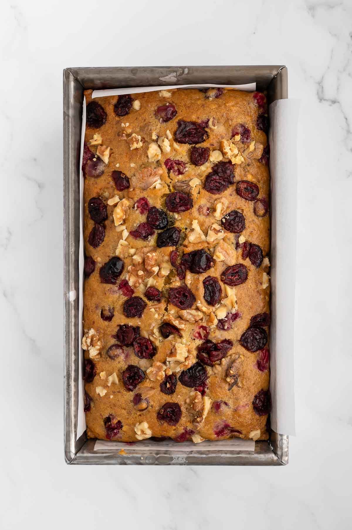A baked loaf of walnut cranberry bread.