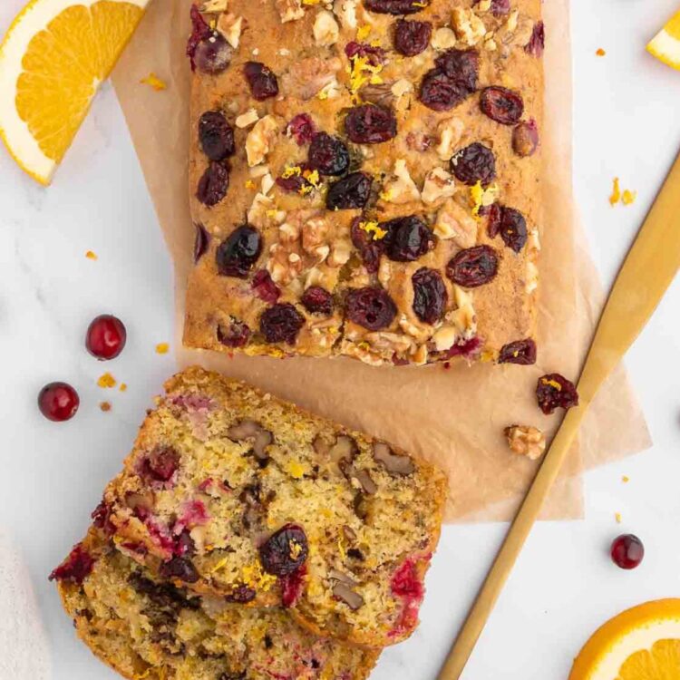 A loaf of walnut cranberry bread, sliced.