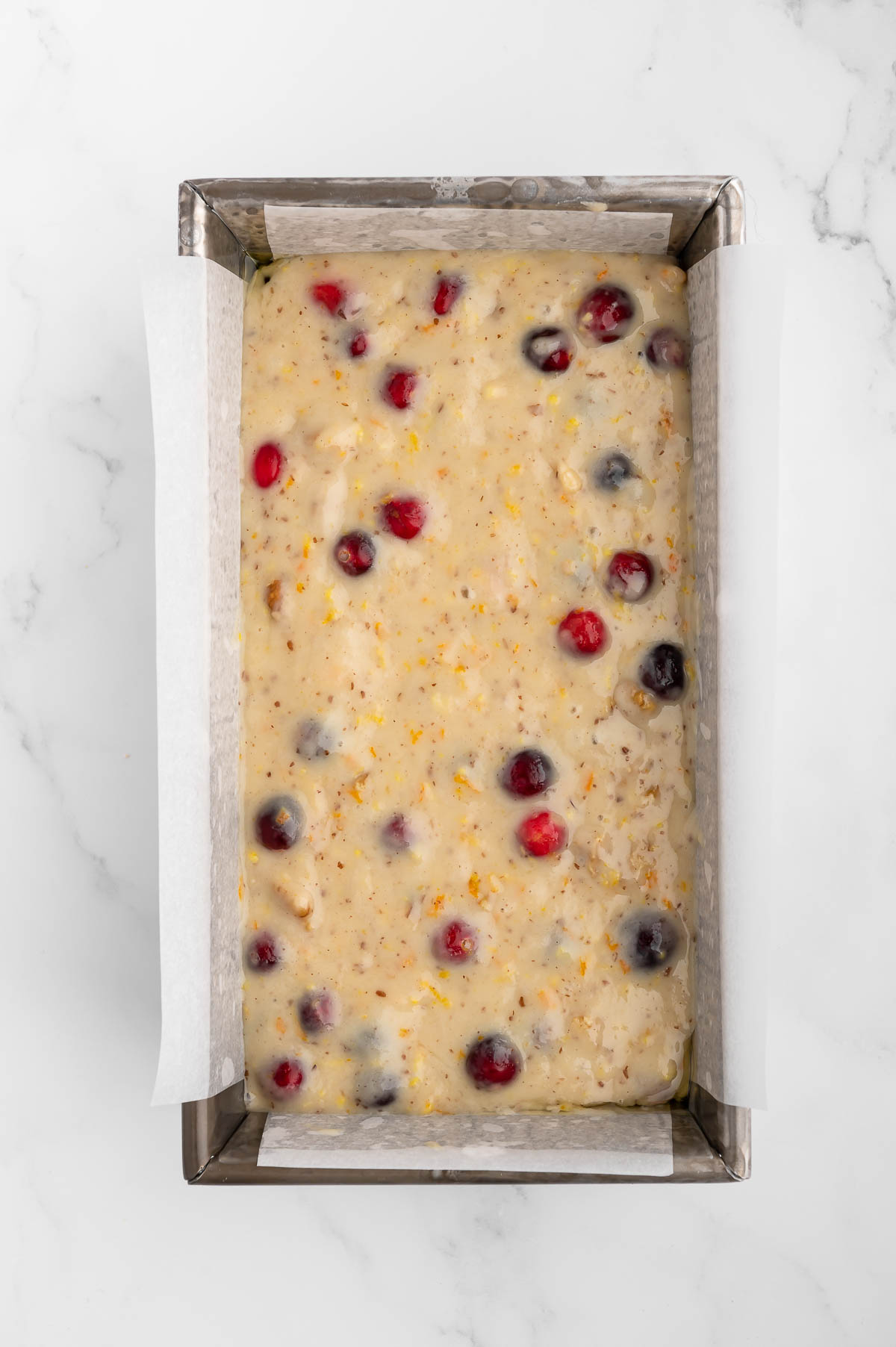 Walnut cranberry bread batter in a loaf pan.