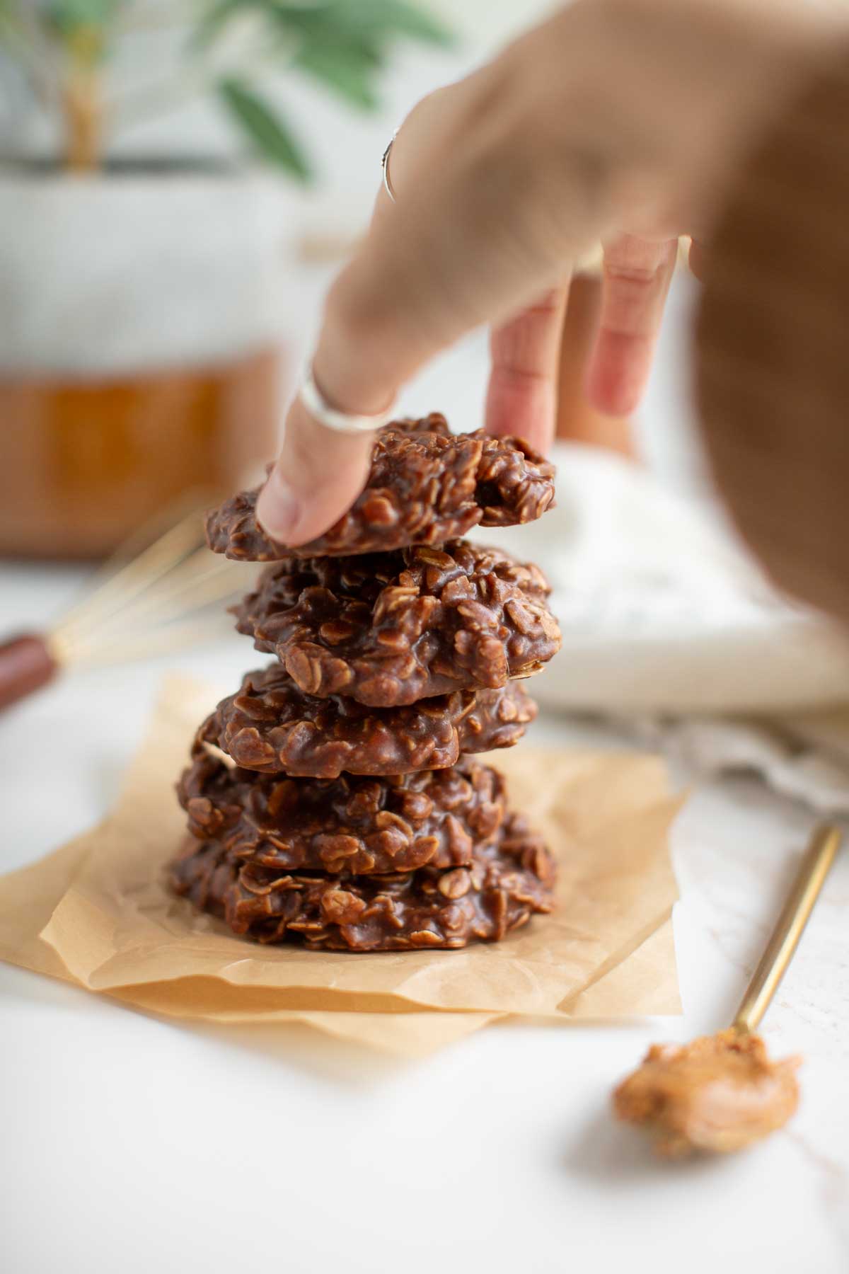 Hands reaching for a stack of vegan no-bake cookies.