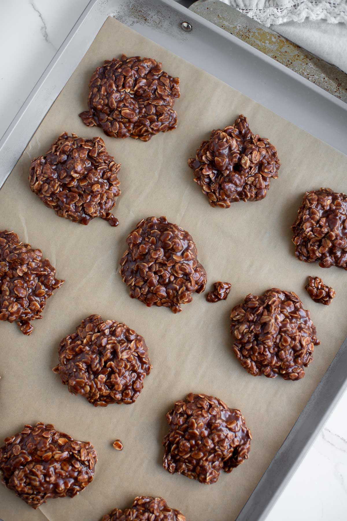 Vegan no-bake cookies resting on a cookie sheet.