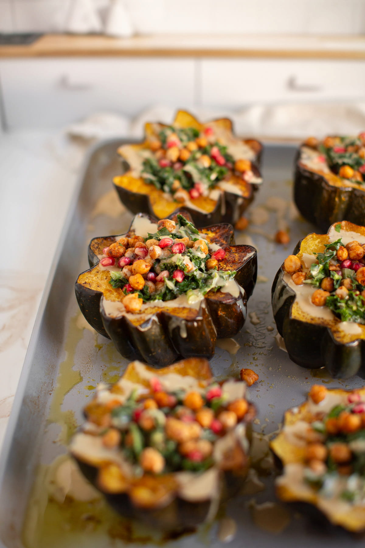 Vegetarian stuffed acorn squash with kale, pomegranate seeds, and chickpeas.