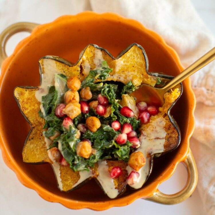 A vegetarian stuffed acorn squash with kale, pomegranate seeds, and chickpeas.