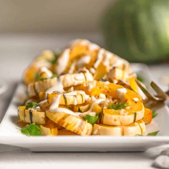 A plate of air-fried delicata squash with a tahini drizzle.