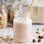 A glass of homemade almond milk with a straw.