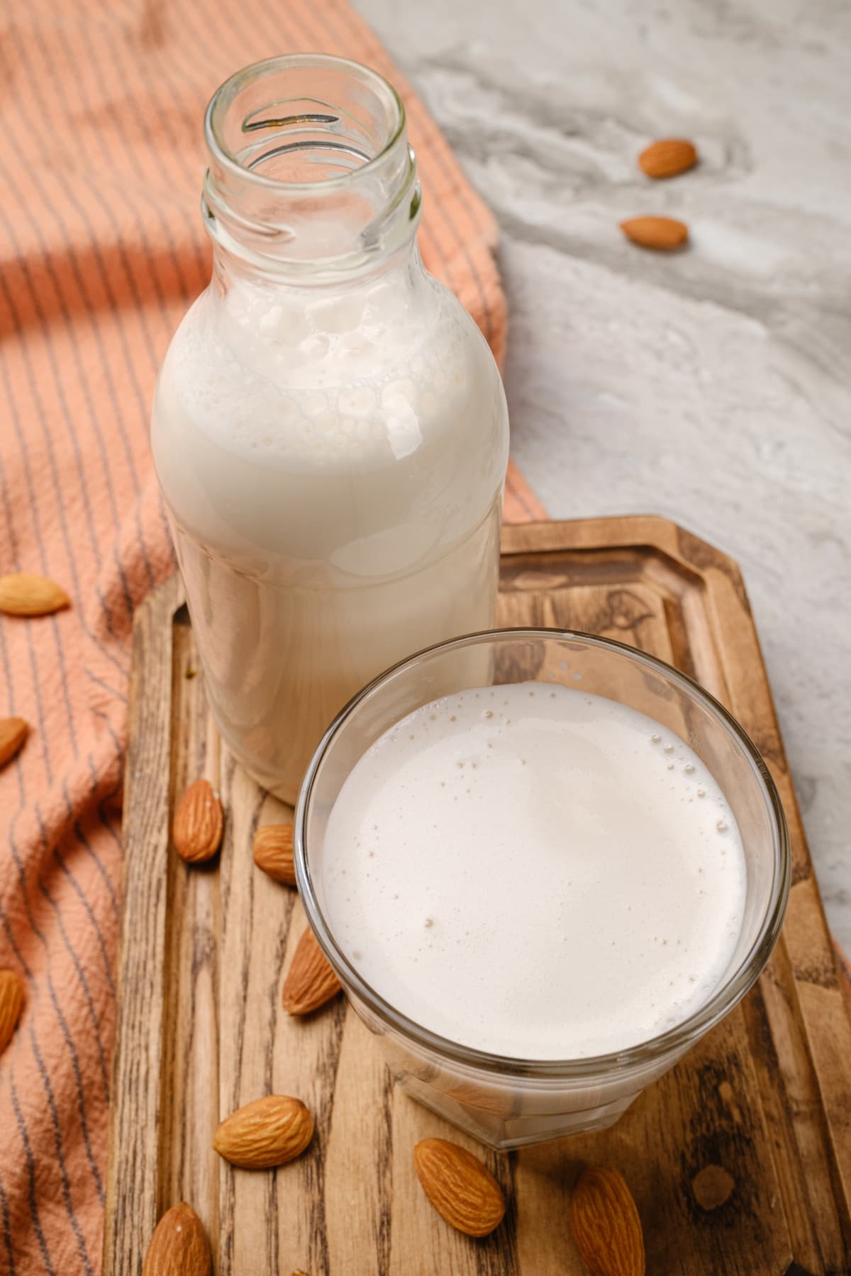 A bottle and glass of dairy-free, homemde almond milk.