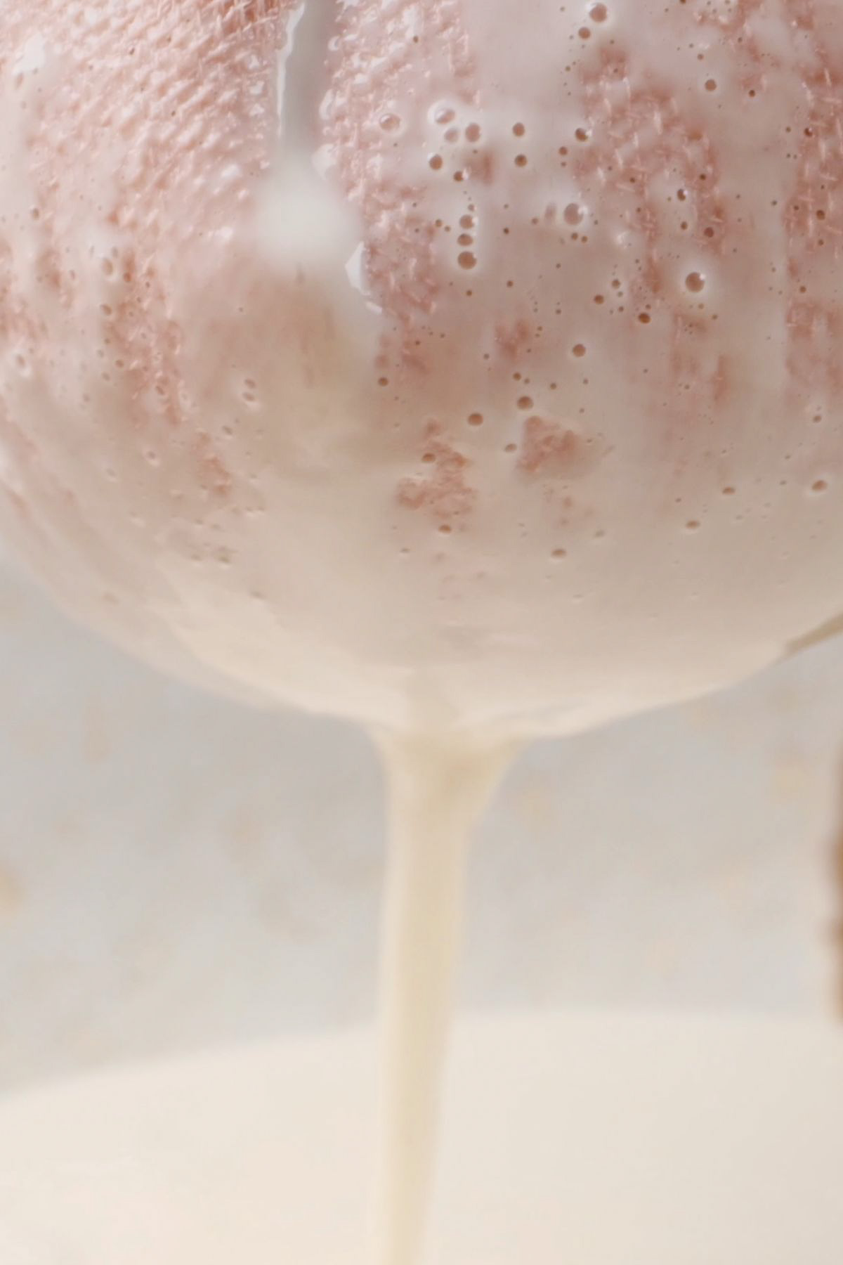 Almond milk being strained through cheesecloth.