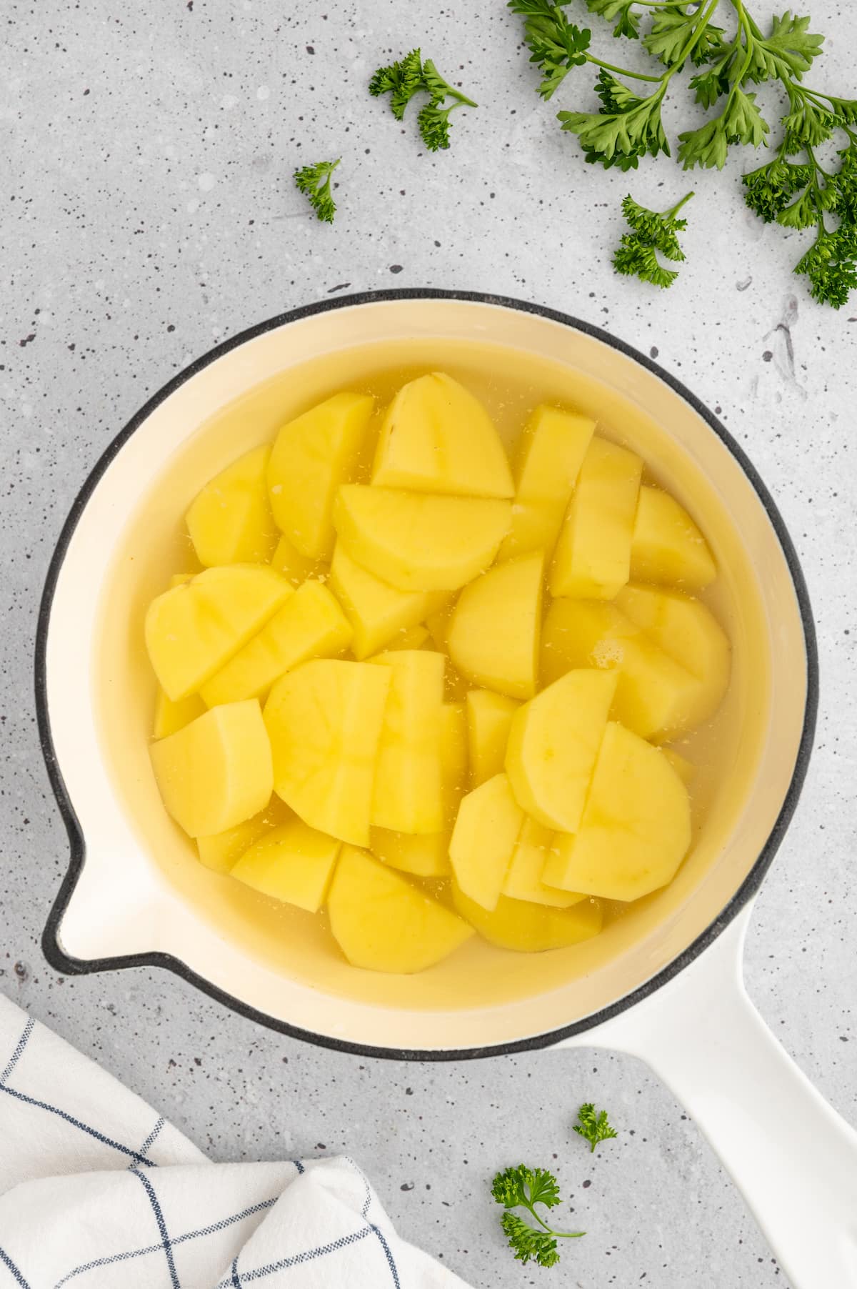 Chopped potatoes in a large pot, covered with water.