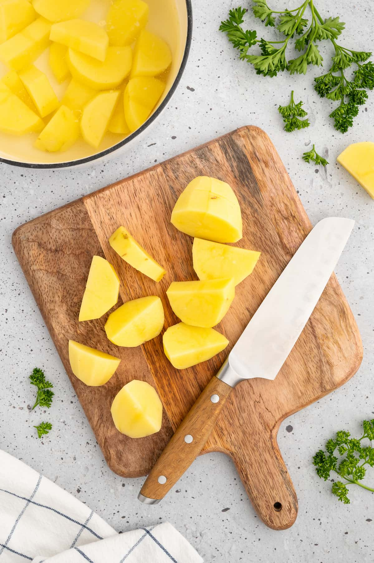 Potatoes chopped into cubes on a cutting board.