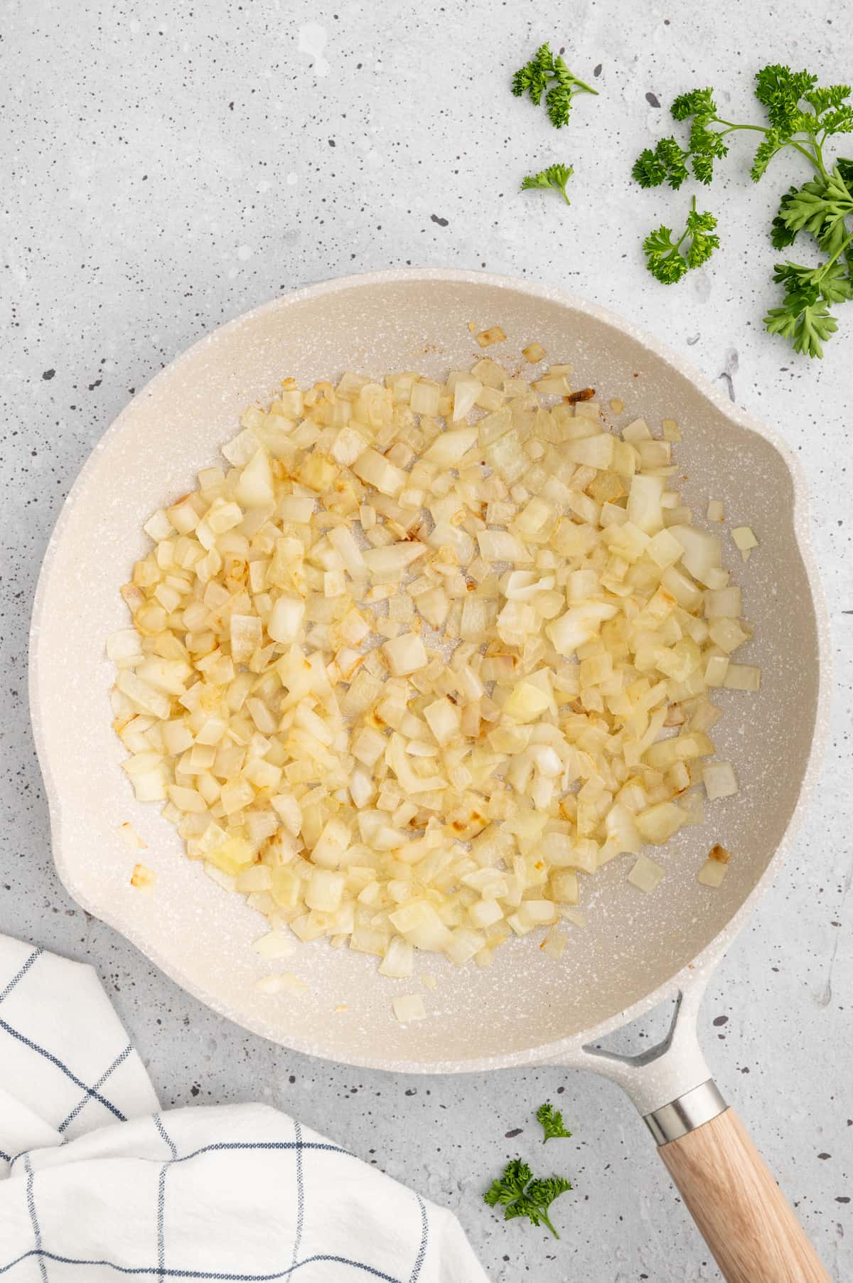 Sauteed diced onions in a skillet.