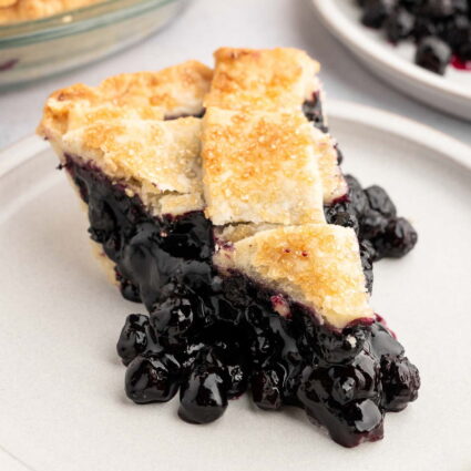 A slice of vegan blueberry pie on a plate.