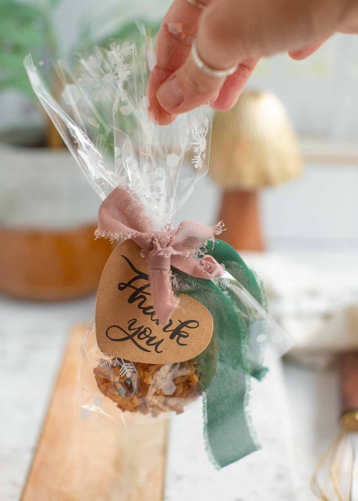 Vegan cookies from Back to Nature in cellophane holiday bags with snowflakes, a green ribbon, and a thank you note attached. 