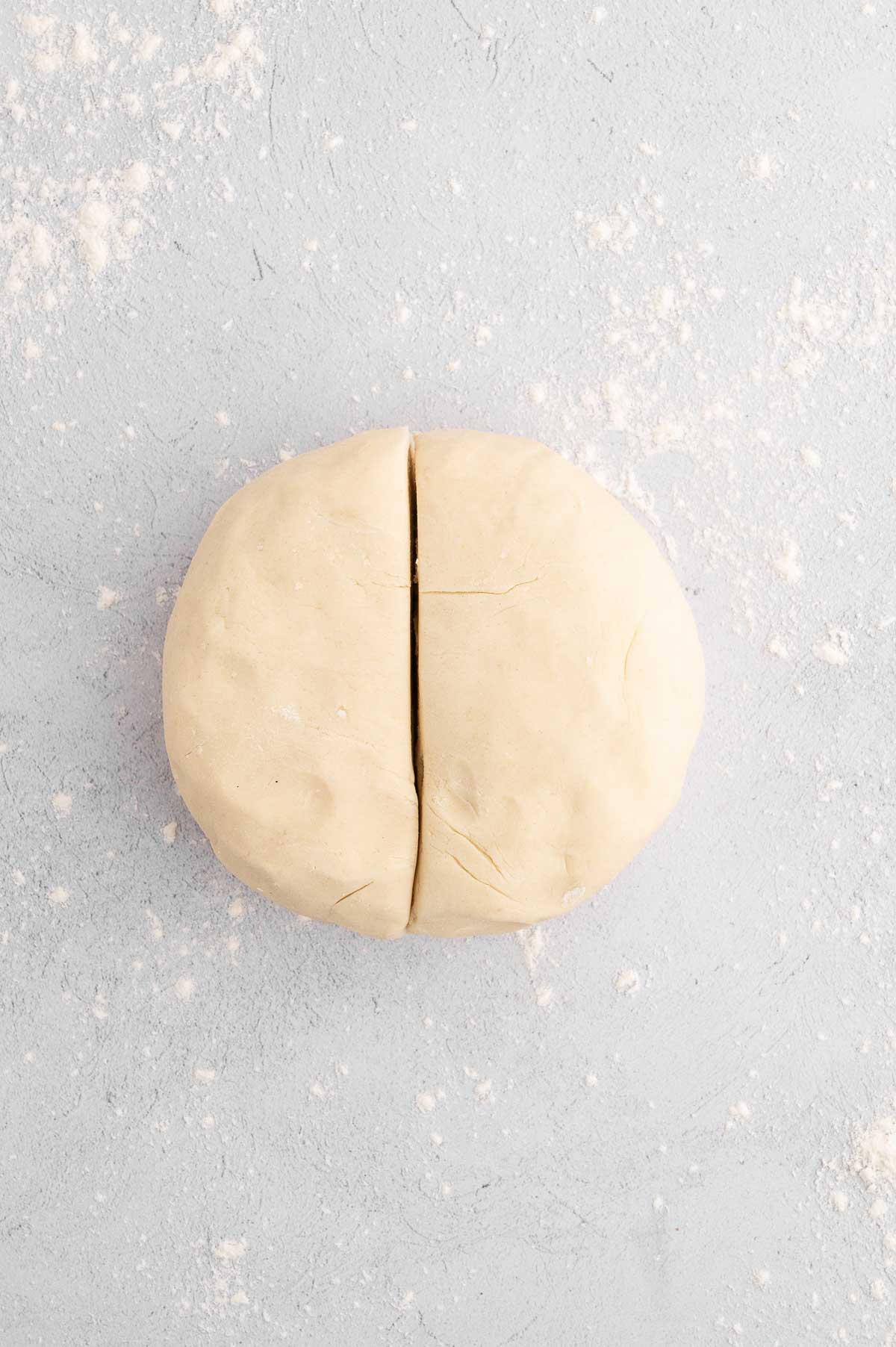 The rolled vegan pie crust dough sliced in half.
