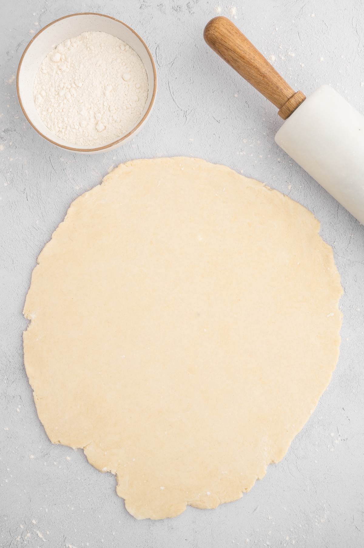 Vegan pie crust rolled out on a floured surface.