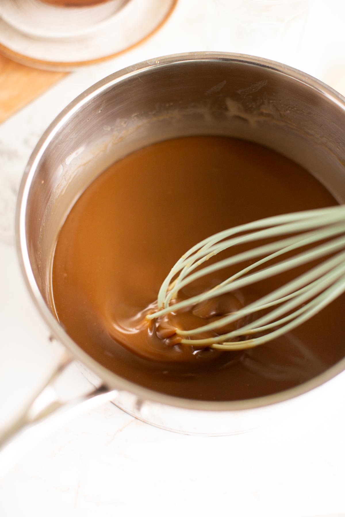 Stirring vegan coconut caramel sauce with a whisk.