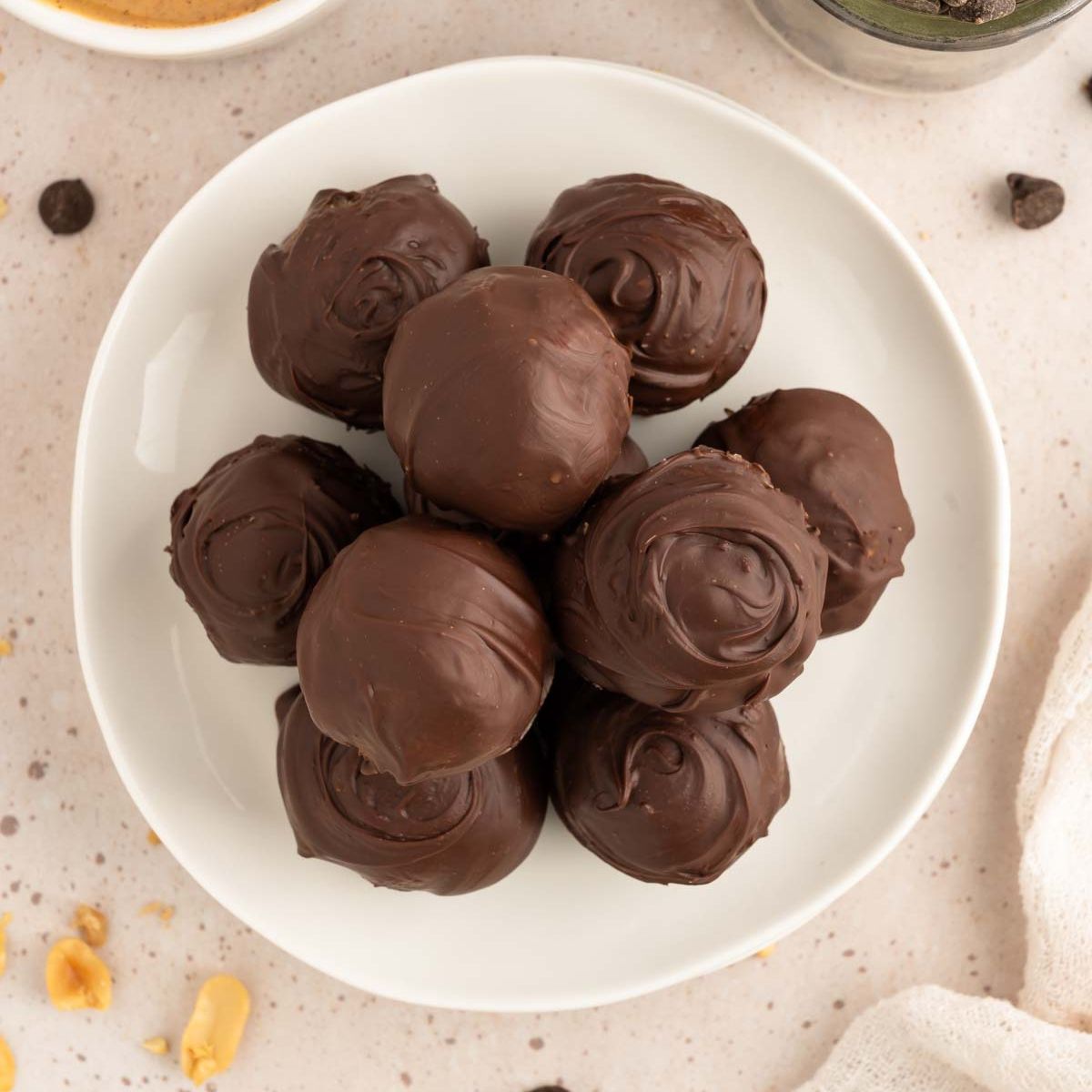 Chocolate-covered cookie dough balls on a plate.