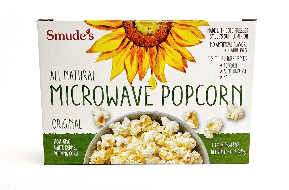 A white and green box with a sunflower of Smude's all natural microwave popcorn against a white background.