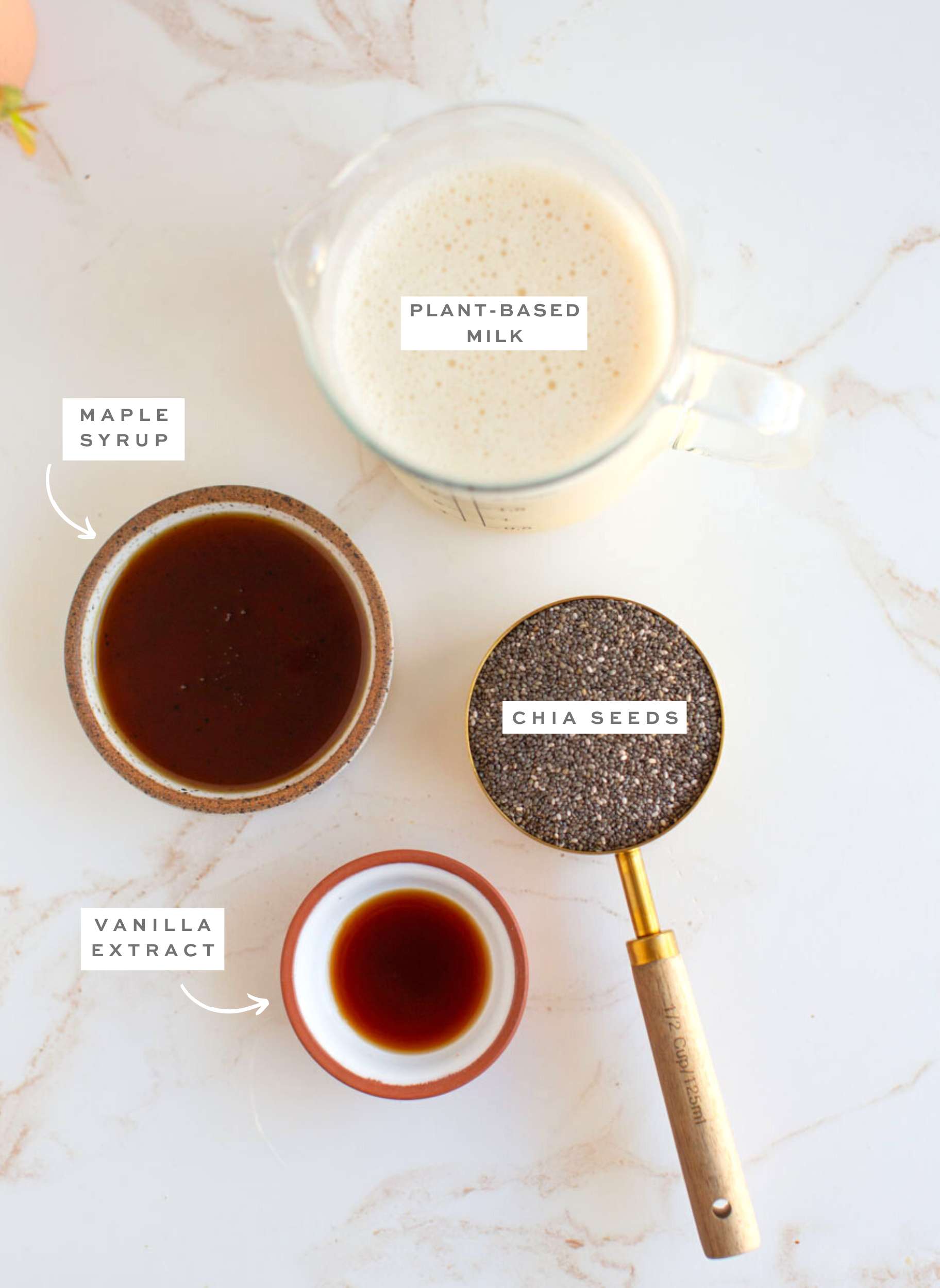 Gathered ingredients for vanilla chia seed pudding in various bowls with labels.