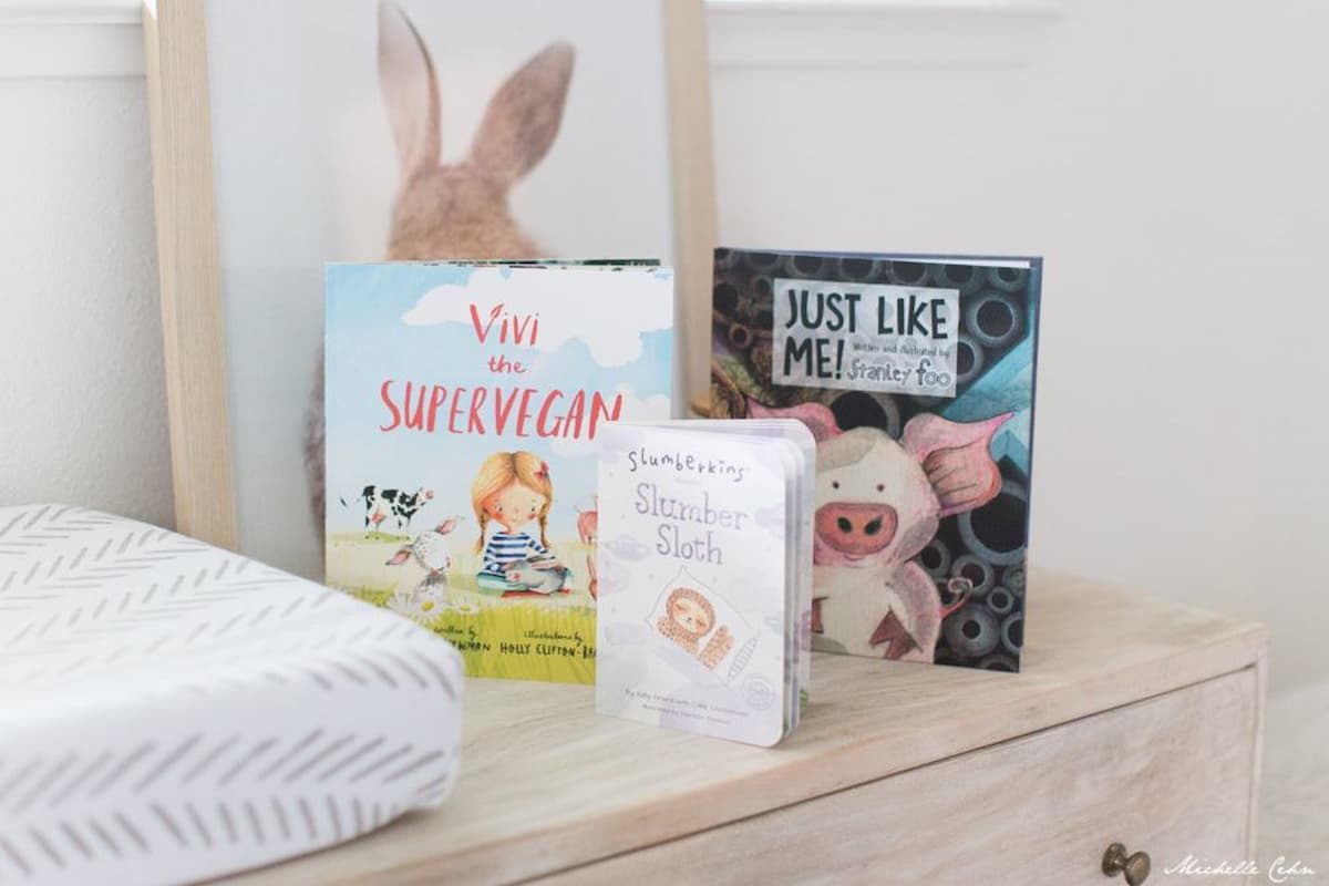 An assortment of vegan baby books on a dresser.